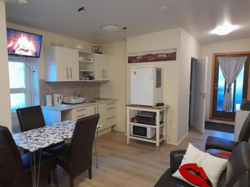 a kitchen with a table and a white refrigerator at Aurora Studio apartment completely private in Keflavík