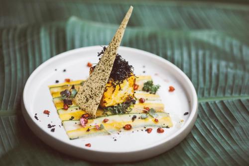 a white plate with a piece of food on it at Six Senses Fort Barwara Sawai Madhopur in Sawāi Mādhopur