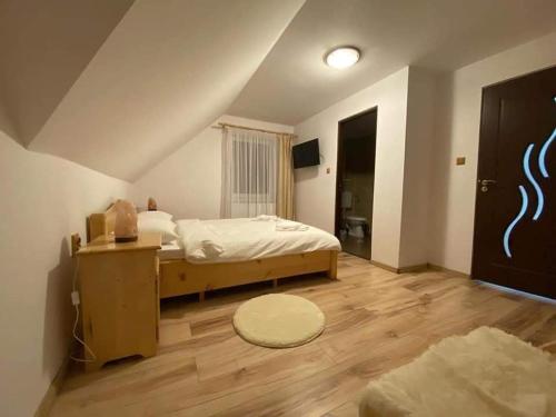 a bedroom with a bed and a wooden floor at Casa Anghel in Bilbor