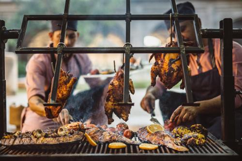 a group of people cooking food on a grill at Six Senses Fort Barwara Sawai Madhopur in Sawāi Mādhopur