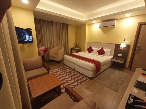 a hotel room with a bed and a couch and a television at Hotel Krishna Kathmandu in Kathmandu