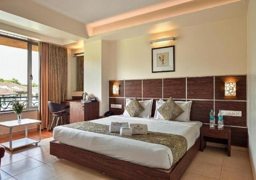 a hotel room with a large bed and a balcony at Meritas Crystal Resort in Lonavala