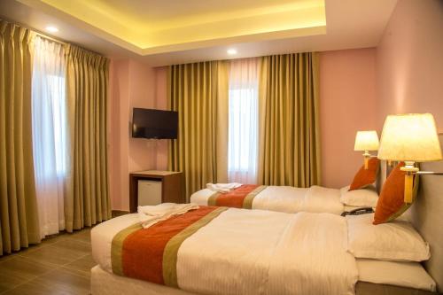 a hotel room with two beds and a flat screen tv at Hotel Krishna Kathmandu in Kathmandu
