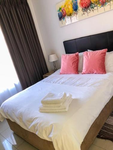 a bedroom with a bed with towels on it at Alendo Apartments in Johannesburg