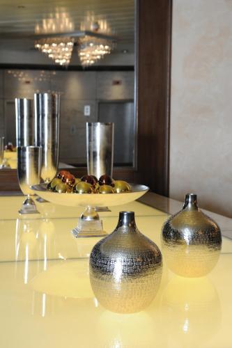 two vases sitting on top of a table with glasses at Maritim Hotel Darmstadt in Darmstadt