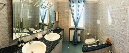 奧爾比亞的住宿－Best Sardegna，浴室设有2个水槽、卫生间和镜子。