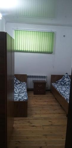 a room with two beds and a window at Guest House 777 in Türkistan