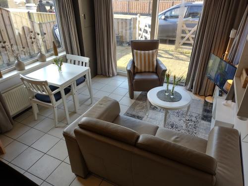 - un salon avec un canapé et une table dans l'établissement TINY HOUSE MIMI Bed by the Sea - Adults only, à Zoutelande