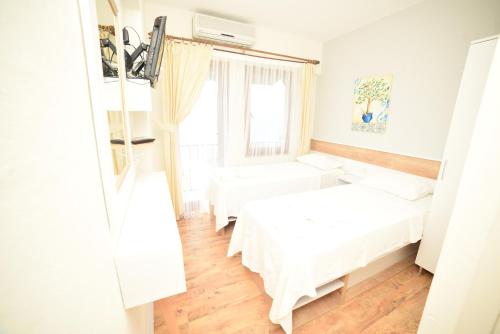 a bedroom with two beds and a window at Limonata Hotel Assos in Behramkale