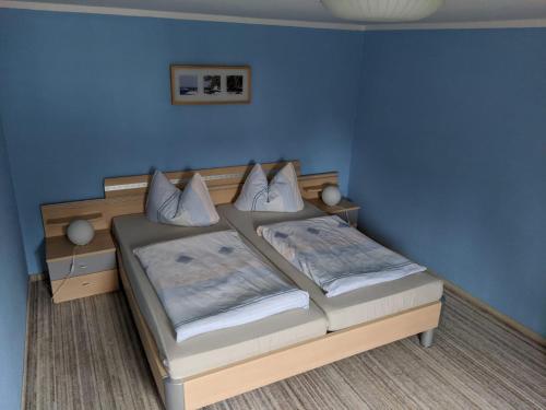 1 Schlafzimmer mit 2 Betten in einem blauen Zimmer in der Unterkunft Pension "Alte Mühle" in Voigtsdorf