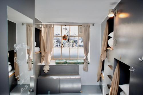 a small room with a window and a window seat at Woodah Boutique Hostel in Copenhagen