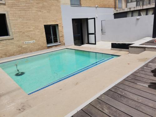 a swimming pool with blue water in a building at Broadway flats Braamfontain in Johannesburg