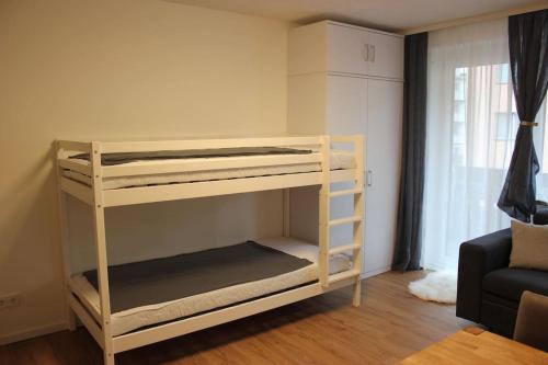 Etagenbett in einem Zimmer mit Sofa in der Unterkunft Gemütliches 4er Apartment in Skilift-Nähe in Zell am See