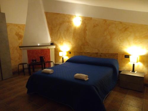 a bedroom with a blue bed with two towels on it at Al vico art in Crosia