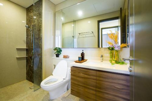 ein Badezimmer mit einem WC, einem Waschbecken und einem Spiegel in der Unterkunft Marigold Apartment Nava Park Central BSD in Tangerang