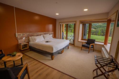 1 dormitorio con 1 cama, mesa y sillas en Calafate Apart Hotel, en Coyhaique