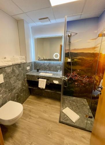 a bathroom with a sink and a shower at Hotel & Restaurant Bergfried in Saalfeld