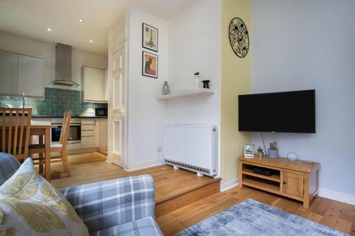 a living room with a couch and a flat screen tv at Sunshine On Leith Apartment in Edinburgh