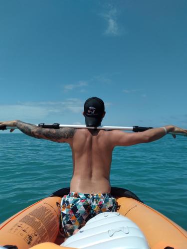 a man holding a surfboard on a raft in the water at Discoverequador in Tonsupa