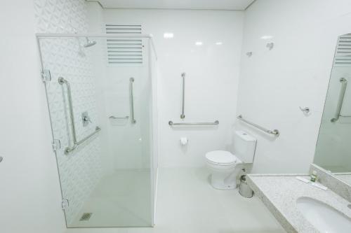een witte badkamer met een douche en een toilet bij CALLAI HOTEL in Toledo