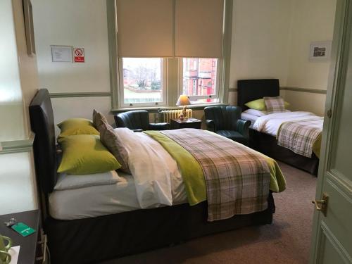 1 dormitorio con 2 camas y ventana en Abberley House, en Carlisle