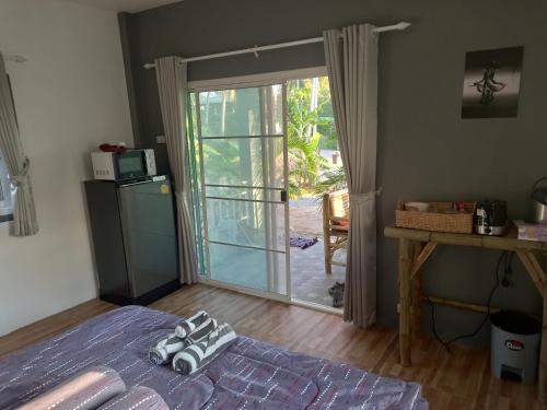 a bedroom with a bed and a sliding glass door at sweet home phangan n5 in Srithanu