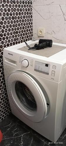 a white washing machine with a remote control on top of it at LUX apartment on Koghbaci in Yerevan