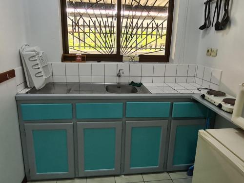 a kitchen with a sink and a window at Kwarts Appartementen in Paramaribo