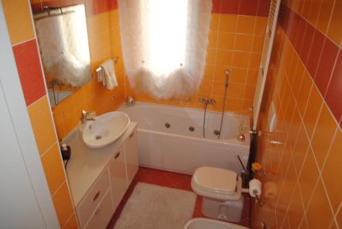 a bathroom with a sink and a toilet and a tub at Appartamento Minerva in Rimini