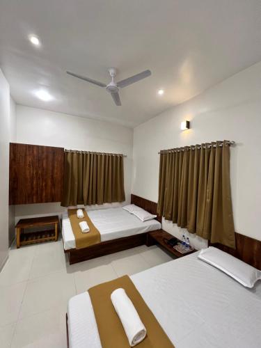 a room with two beds and a ceiling at Darshan Executive in Kolhapur