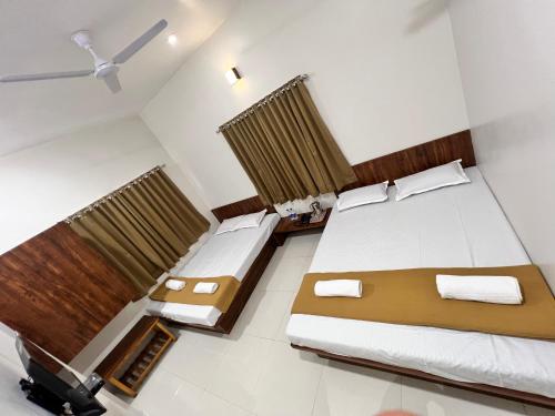 a hotel room with two beds and curtains at Darshan Executive in Kolhapur