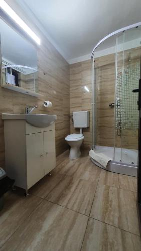 a bathroom with a toilet and a sink and a shower at Motel Pacific in Deva