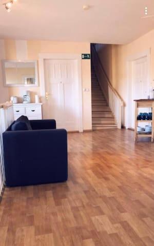 a living room with a couch and a staircase at Ela Apartments Berlin in Berlin