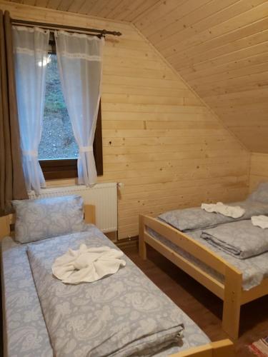 two beds in a room with a window at Balendormi in Gheorgheni