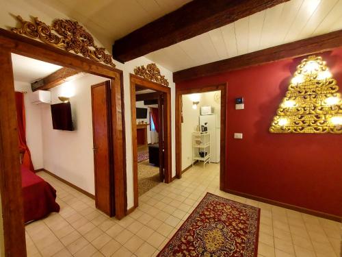 a hallway with a room with red walls and a chandelier at Palazzo del Sale, Rialto in Venice
