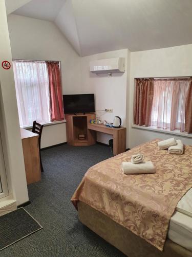 a hotel room with a bed and a television at Guest House Gurkov in Veliko Tŭrnovo
