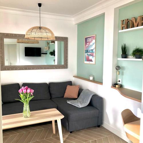 ein Wohnzimmer mit einem Sofa und einem Tisch in der Unterkunft Bel appartement rénové, centre de Vannes in Vannes