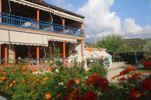 a building with a flower garden in front of it at Guesthouse Rondo in Himare
