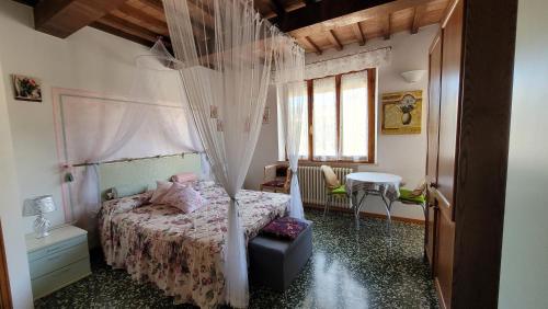 a bedroom with a bed with a canopy at Camera La Margherita in San Quirico dʼOrcia