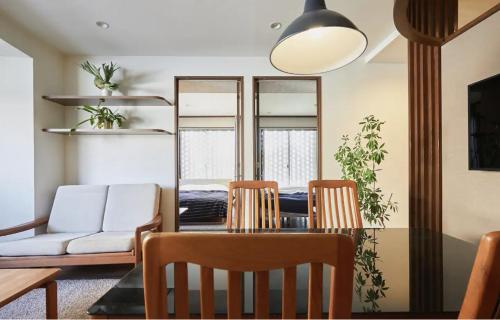 a dining room with a table and chairs and a couch at Kyodo Private House in Tokyo