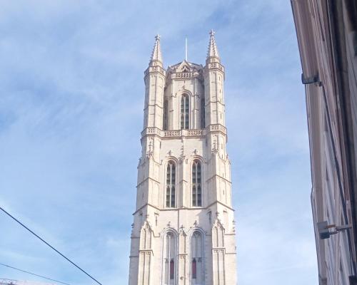 a tall white tower with a clock on it at STUDIO61 in Ghent