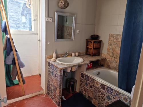 a bathroom with a sink and a bath tub at Un nid sur les toits in Avignon