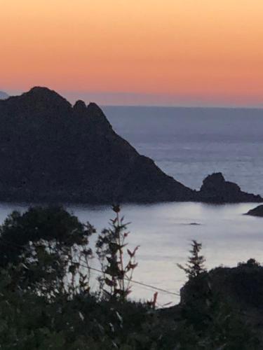 a sunset over a body of water with mountains at Il Belvedere - Cannelle beach Argentario - Tuscany in Monte Argentario