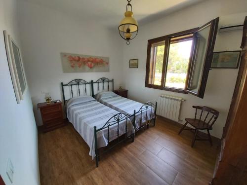 a bedroom with a bed and a window and a chair at Villa del Sole in Manduria