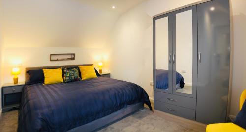 ein Schlafzimmer mit einem Bett, einer Kommode und einem Spiegel in der Unterkunft Kettlesing Cottage, Harrogate in Harrogate