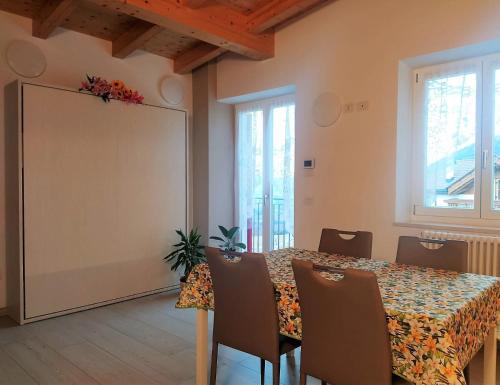 a dining room with a table with chairs and a large screen at Appartamenti Il Cerbiatto in Cavedago