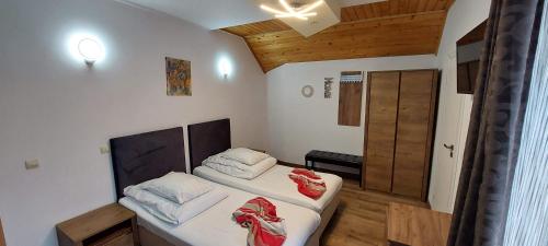 ブラショヴにあるPensiunea Riunioneの木製の天井が特徴の小さな客室で、ベッド2台が備わります。