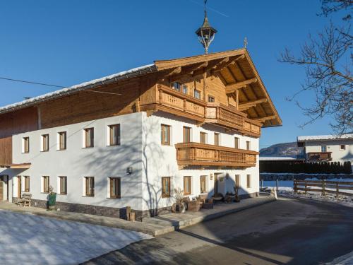 a large white building with a wooden roof at Ferienwohnung Döllerer in Kössen
