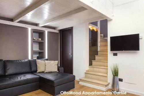 salon z kanapą i telewizorem na ścianie w obiekcie Ottomood House Catania w Katanii