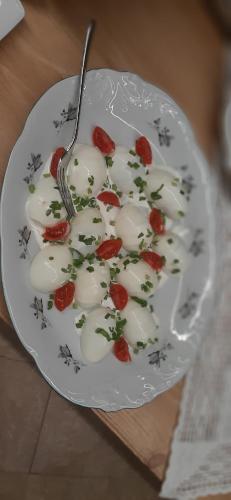 a plate with tomatoes and a fork on a table at Apartamenty i pokoje Pod Limbami - sauna, tężnia in Bukowina Tatrzańska